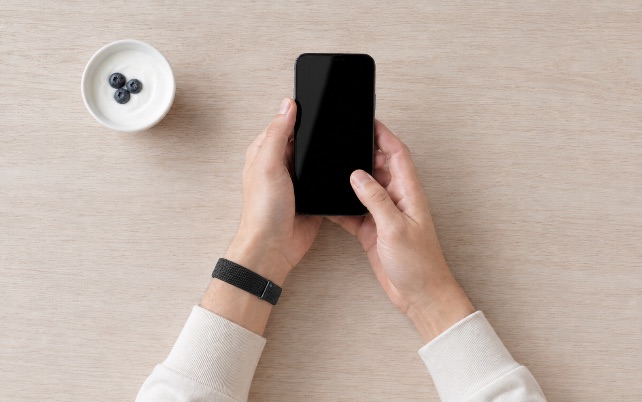 Hands logging a meal in the GLP Care app at a table